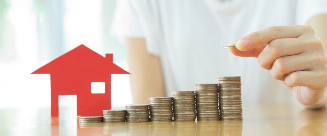 Real estate investment. House and coins on table.
